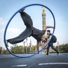 DEU Germany Germany Berlin A street acrobat performs in a tyre in front of the golden donkey
