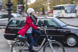 DEU Germany Germany Berlin A cyclist rides with a suitcase on the pavement