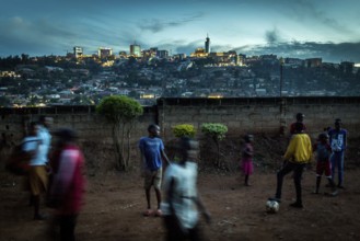 RWA RWANDA RUANDA Kigali Children playing football on a dusty path In the background, the Kiyovu