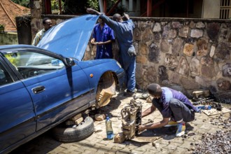 RWA RWANDA RUANDA Kigali Car mechanics dismantle the engine of a car on the street