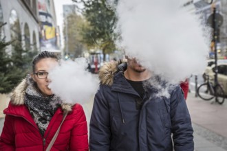 DEU Germany Germany Berlin A couple with an e-cigarette blowing out vapour
