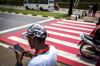 RWA RWANDA RUANDA Kigali A youth with a camouflage baseball cap looks at his mobile phone while