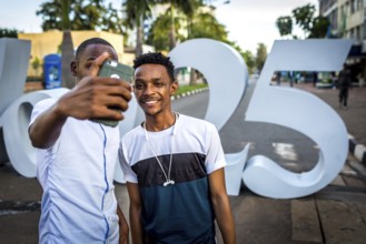 RWA RWANDA RUANDA Kigali People take a photo of themselves at the sign commemorating the genocide
