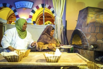 Egypt Hurghada Two elderly Egyptian women bake bread during an evening promotional event for