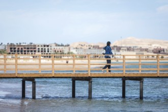 Egypt Hurghada A Muslim woman on a footbridge against the backdrop of unfinished hotel complexes