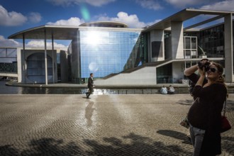 DEU Germany Germany Berlin Passers-by walk along the Spree, where the sun is reflected in the