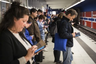 DEU Germany Germany Berlin Passengers look at their mobile phones while waiting for the train at