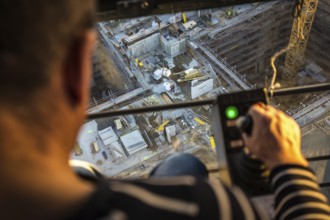 DEU Germany Germany Berlin A crane operator is transporting building materials on a construction