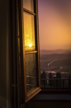 ITA Italy Castelfalfi View through a hotel window of the Tuscan countryside at sunset