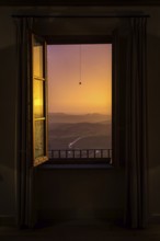 ITA Italy Castelfalfi View through a hotel window of the Tuscan countryside at sunset