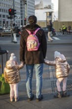 DEU Germany Germany Berlin A father holds hands with his twin daughters at a pedestrian crossing on