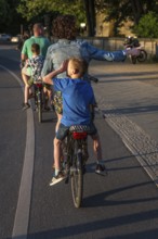 DEU Germany Germany Berlin Parents with their children on the pannier rack during a bike tour