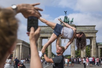 DEU Germany Germany Berlin A couple poses as a dancing figure in front of the Brandenburg Gate
