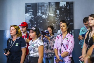 POL Poland Poland Auschwitz Visitors listen to their audio guide at the memorial site of the former
