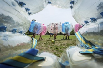 DEU Germany Germany Berlin A group of Dutch tourists playing bubblesoccer in a meadow in Volkspark