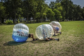 DEU Germany Germany Berlin A group of Dutch tourists playing bubblesoccer in a meadow in Volkspark
