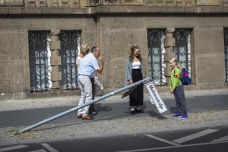 DEU Germany Germany Berlin A man shows a strong arm while a schoolgirl looks at a knocked down