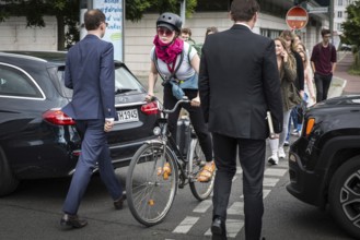 DEU Germany Germany Berlin Cyclist and pedestrian queue through heavy traffic on