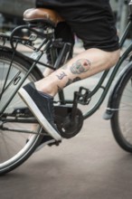 DEU Germany Germany Berlin A skull tattoo on a cyclist's leg