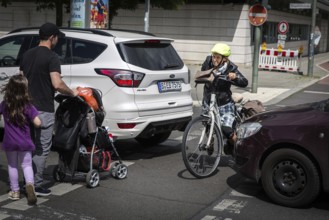 DEU Germany Germany Berlin Cyclist and pedestrian queue through heavy traffic on