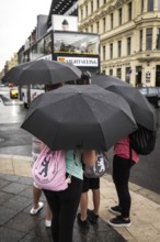 DEU Germany Germany Berlin Tourists with umbrellas at Checkpoint Charlie