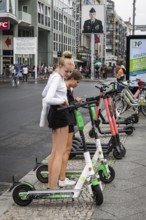 DEU Germany Germany Berlin Tourists with e-scooters at Checkpoint Charlie