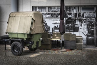 DEU Germany Germany Berlin Ammunition boxes and a military trailer in front of a photo from the