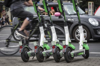 DEU Germany Germany Berlin Traffic passes parked e-scooters on Karl-Liebknecht-Str