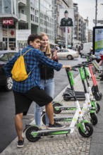 DEU Germany Germany Berlin Tourists with e-scooters at Checkpoint Charlie