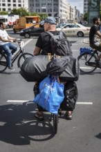 DEU Germany Germany Berlin Cyclist with numerous pieces of luggage on his bike passes Potsdamer