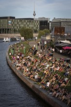 DEU Germany Germany Berlin In summer temperatures, people sit on the Spreebogen and enjoy the