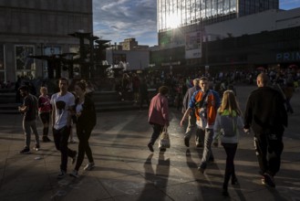 DEU Germany Germany Berlin People in the light at Alexanderplatz