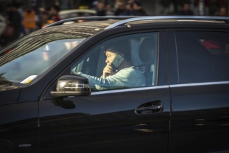 DEU Germany Germany Berlin A man talks on the phone while driving his SUV across Potsdamer Platz