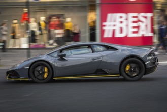 DEU Germany Germany Berlin A Lamborghini passes a shop window advert on the Kudamm