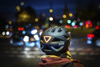 DEU Germany Germany Berlin A cyclist wearing a helmet with LED light waits at a traffic light on