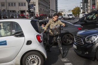 DEU Germany Germany Berlin Cyclists squeeze between stationary cars on Potsdamer Platz