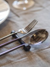 Utensils elegantly resting on an industrial bolt creating a unique table setting