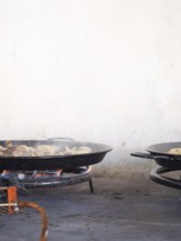 Paella pan on a gas burner cooking ingredients, preparing spanish food