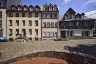 Historic buildings, houses, downpipes, façade with windows, dormers, stairs and doors, paving stone