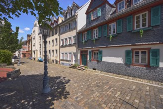 Historic building, houses, dormers, façade with windows, stairs and door, paving stone walkway,