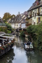 Traditional houses along a river, here called the little Venice, with tourists visiting Colmar on a