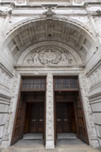 London, United Kingdom - 15 May 2025: Massive carved wooden doors beneath the highly ornate arch of
