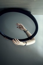 Portrait of a woman behind a mirror, hand in front of the mirror, interior view