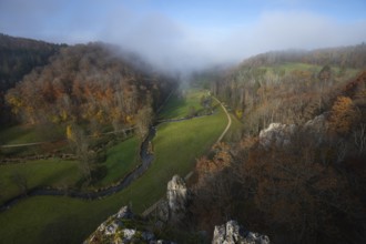 Autumn landscape with rising fog over the Grosse Lauter river loop in Lautertal at sunrise. View