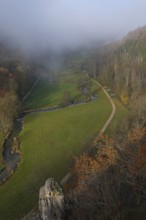 Autumn landscape with rising fog over the Grosse Lauter river loop in Lautertal at sunrise. View