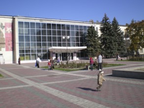 Residents of Melitopol with their children stroll through Victory Square near the Shevchenko