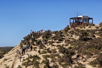 Hiker on a hill trail with views and an observation point in the blue sky, The countryside of