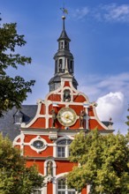 Magnificent baroque building with clock and decorative bell tower against a blue sky, the old town