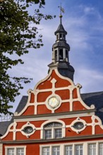 Red building with decorative bell tower, clear sky in the background, historic ambiance, the old