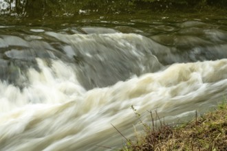 Borken-Hoxfeld, NRW, Germany, Water cascades smoothly over rocks, creating gentle waves along the
